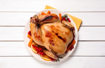 Photo of Delicious cooked turkey served on white wooden table, flat lay. Thanksgiving Day celebration