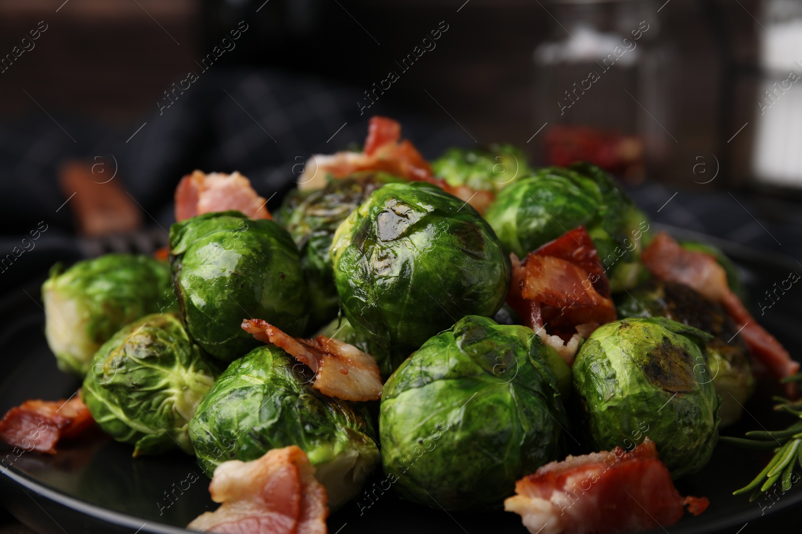 Photo of Delicious roasted Brussels sprouts and bacon on plate, closeup