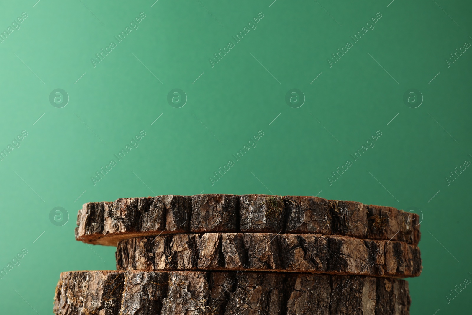 Photo of Presentation for product. Wooden stumps on green background. Space for text