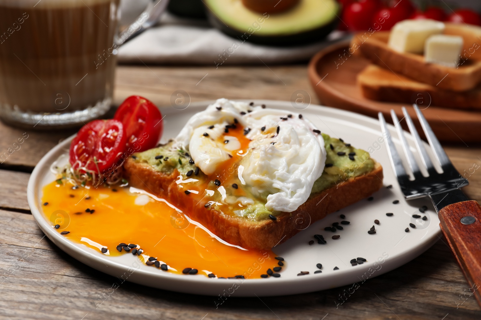 Photo of Delicious toast with poached egg and avocado served on wooden table