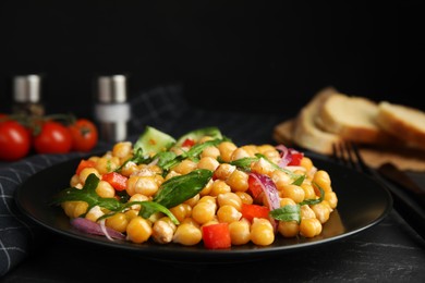 Photo of Delicious fresh chickpea salad on black table, closeup