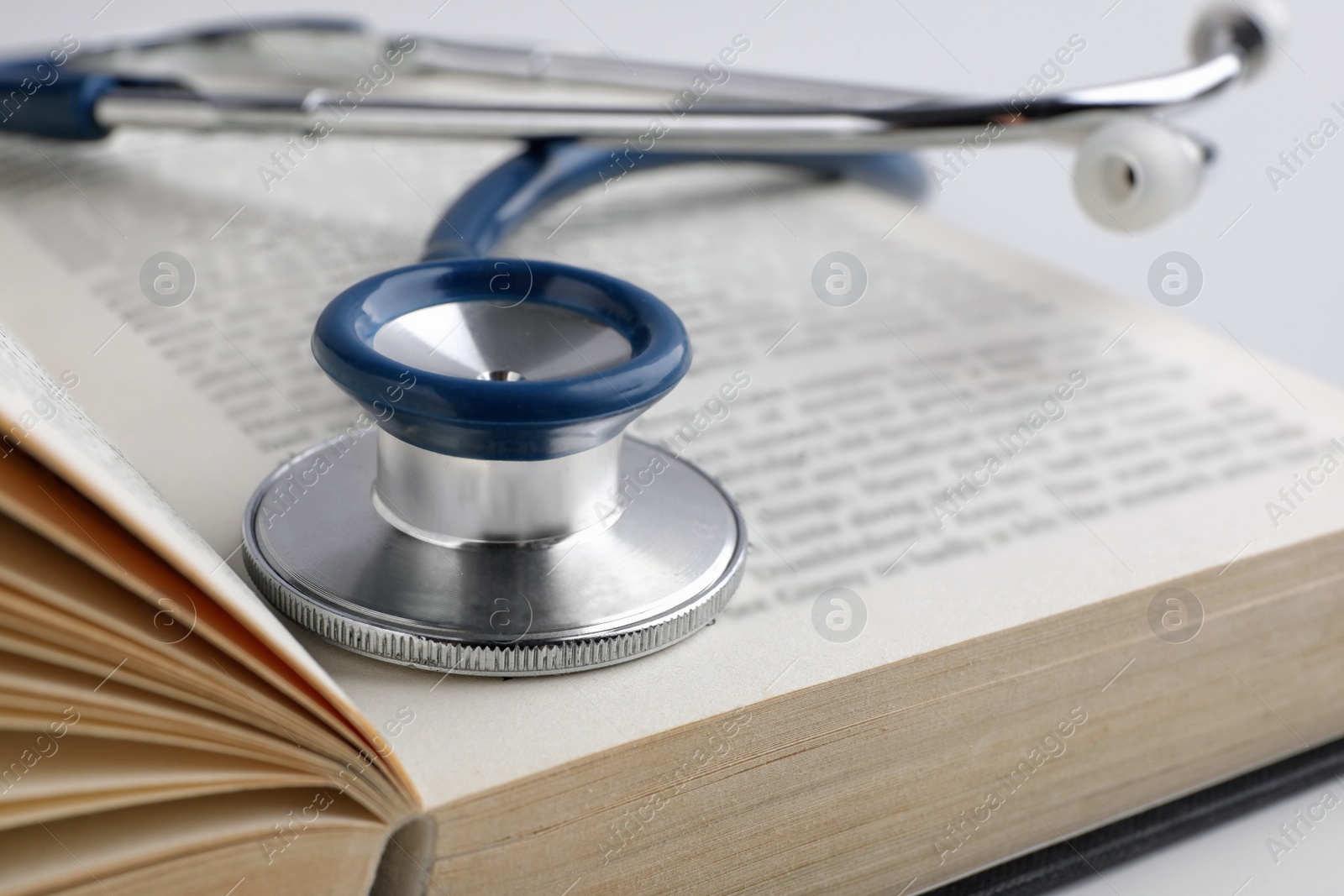 Photo of Open student textbook with and stethoscope, closeup. Medical education