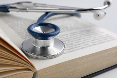 Photo of Open student textbook with and stethoscope, closeup. Medical education