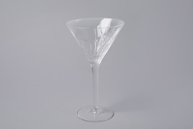 Empty clean martini glass on grey background