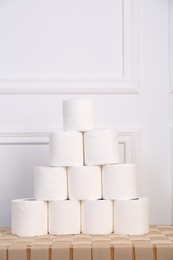 Photo of Pyramid of toilet paper rolls on wicker table