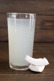 Photo of Glass of coconut water and nut on wooden table