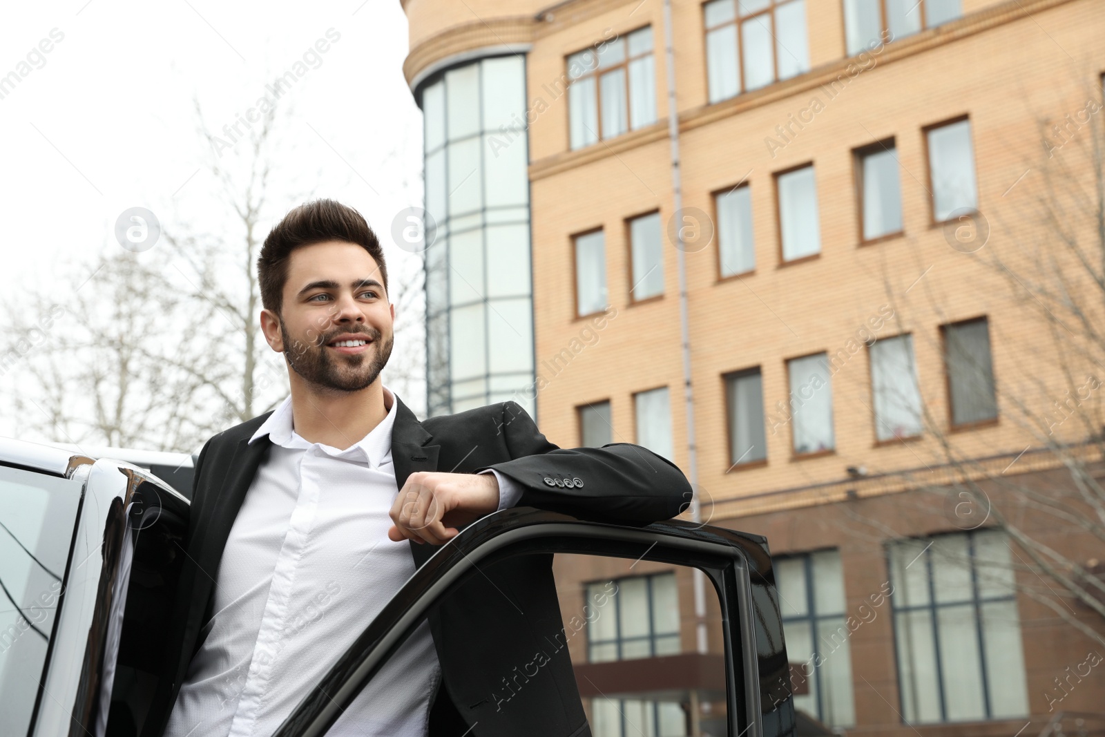 Photo of Handsome young man near modern car outdoors