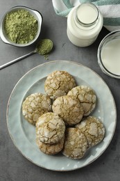 Tasty matcha cookies, powder and milk on grey table, flat lay