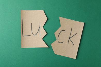 Photo of Cut paper with word LUCK on green background, flat lay