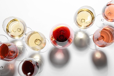 Different glasses with wine on white background, top view