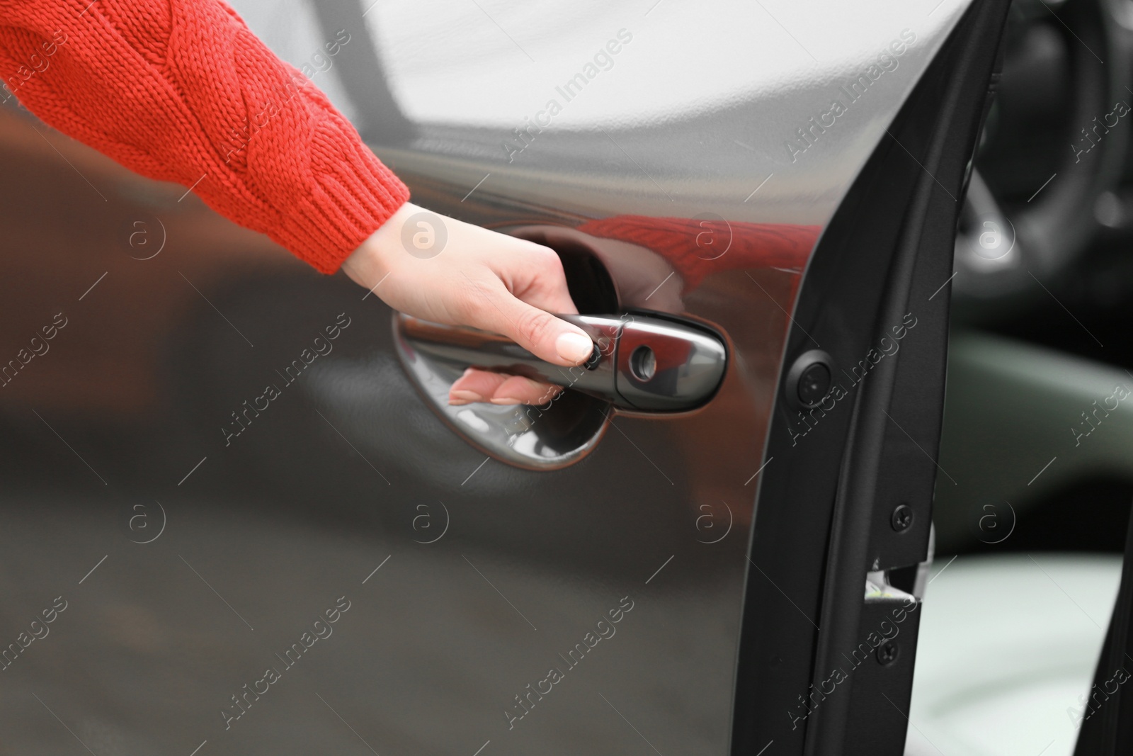 Photo of Closeup view of woman opening car door