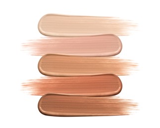 Different shades of liquid skin foundation on white background, top view