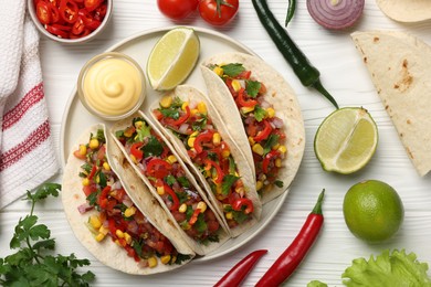 Photo of Tasty tacos with vegetables on white wooden table, flat lay