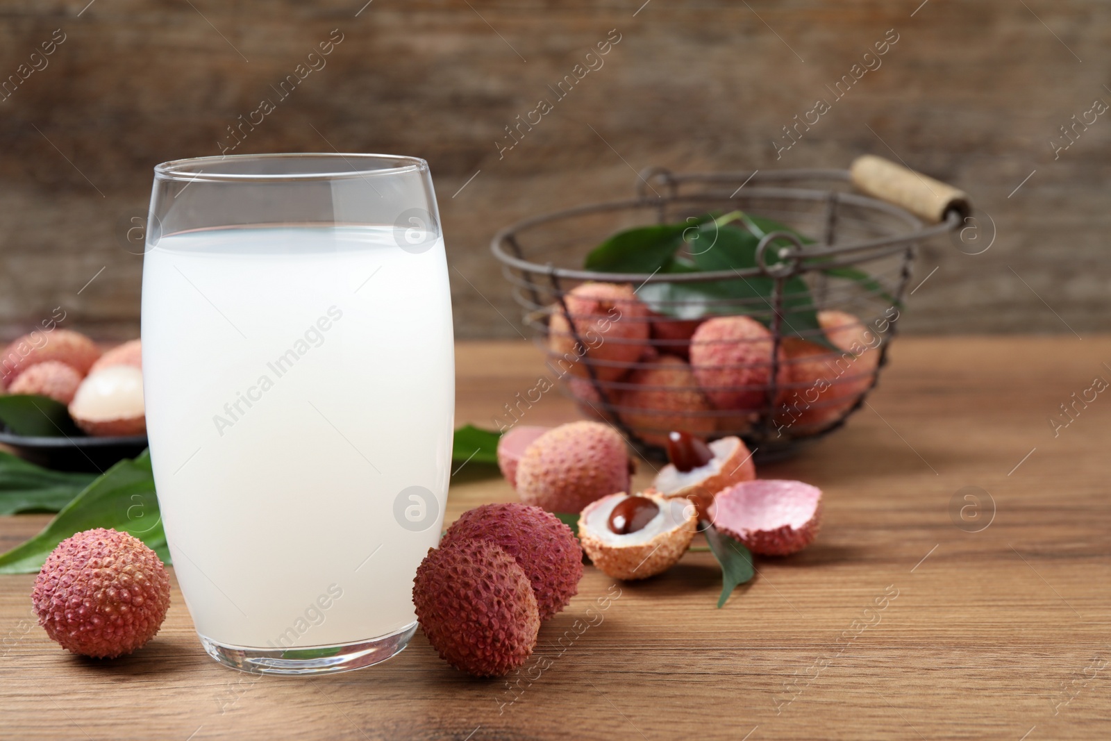 Photo of Fresh lychee juice and fruits on wooden table