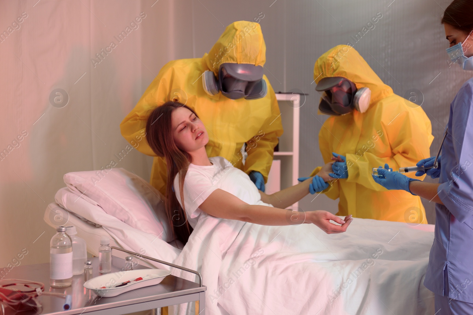 Photo of Professional paramedics examining patient with virus in quarantine ward