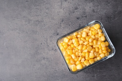 Photo of Bowl with corn kernels on grey background, top view. Space for text