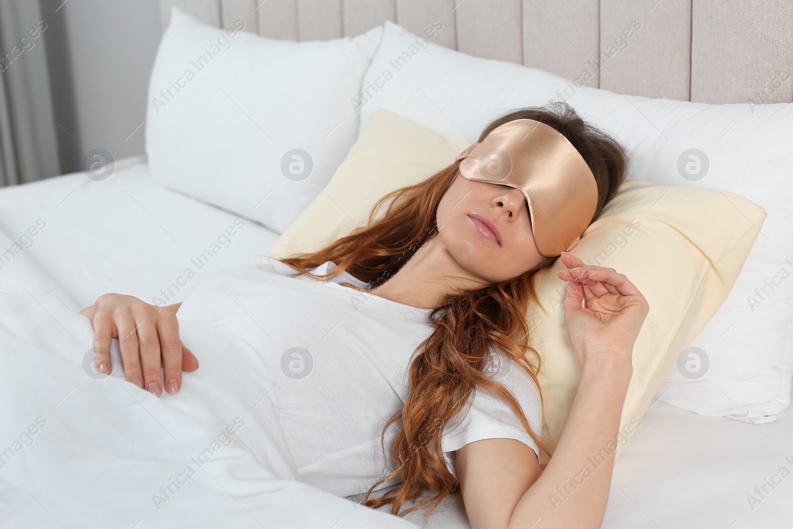 Photo of Woman with sleep mask in bed at home