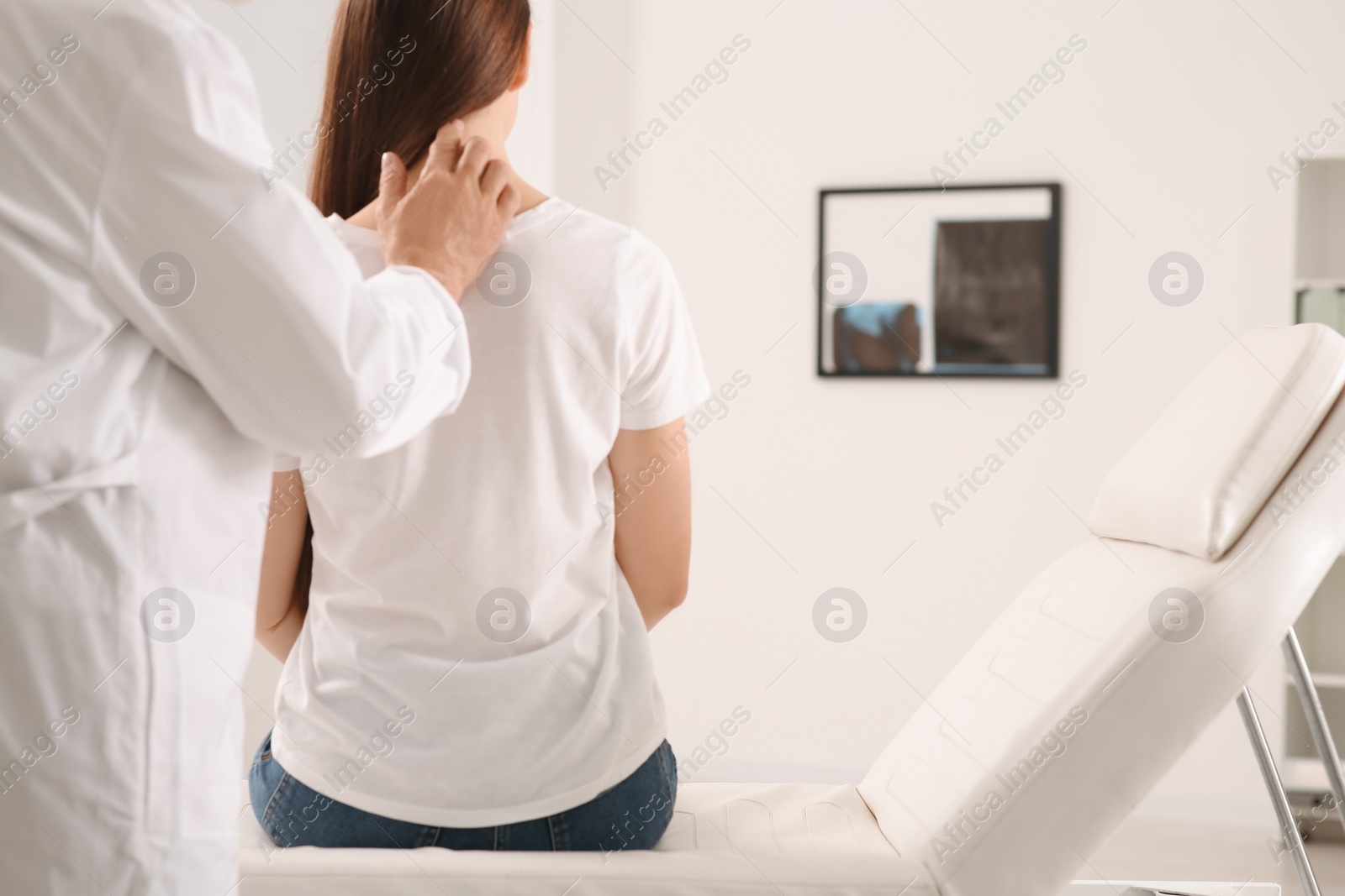 Photo of Professional orthopedist examining patient's neck in clinic, closeup