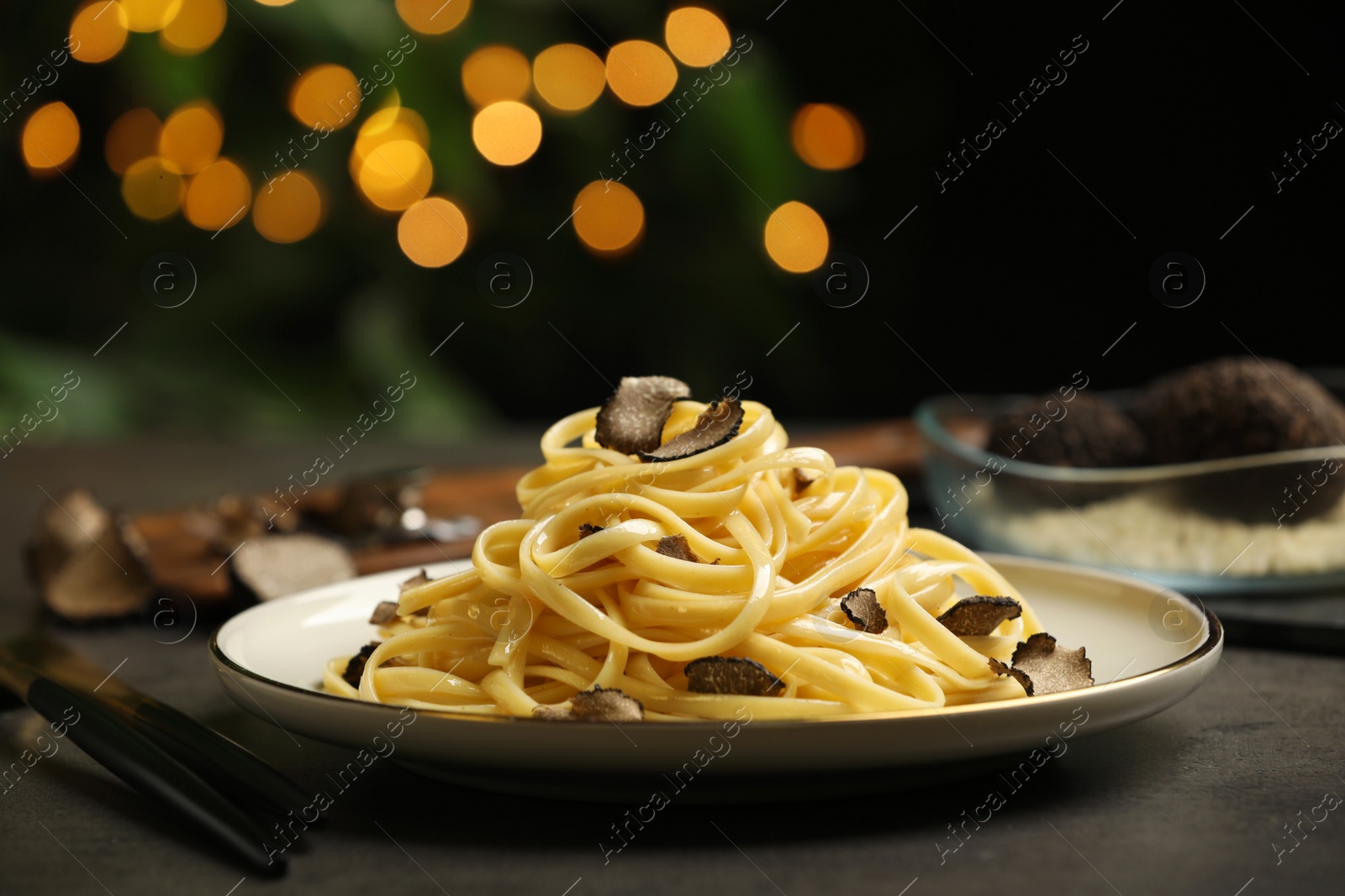 Photo of Tasty fettuccine with truffle on grey table