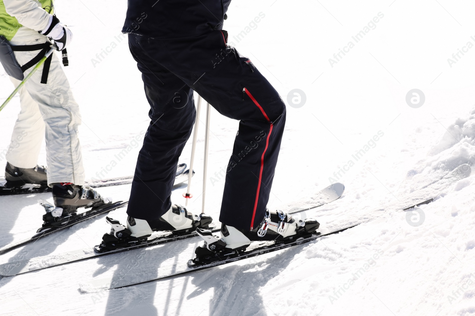 Photo of People skiing on snowy hill in mountains, closeup view. Winter vacation