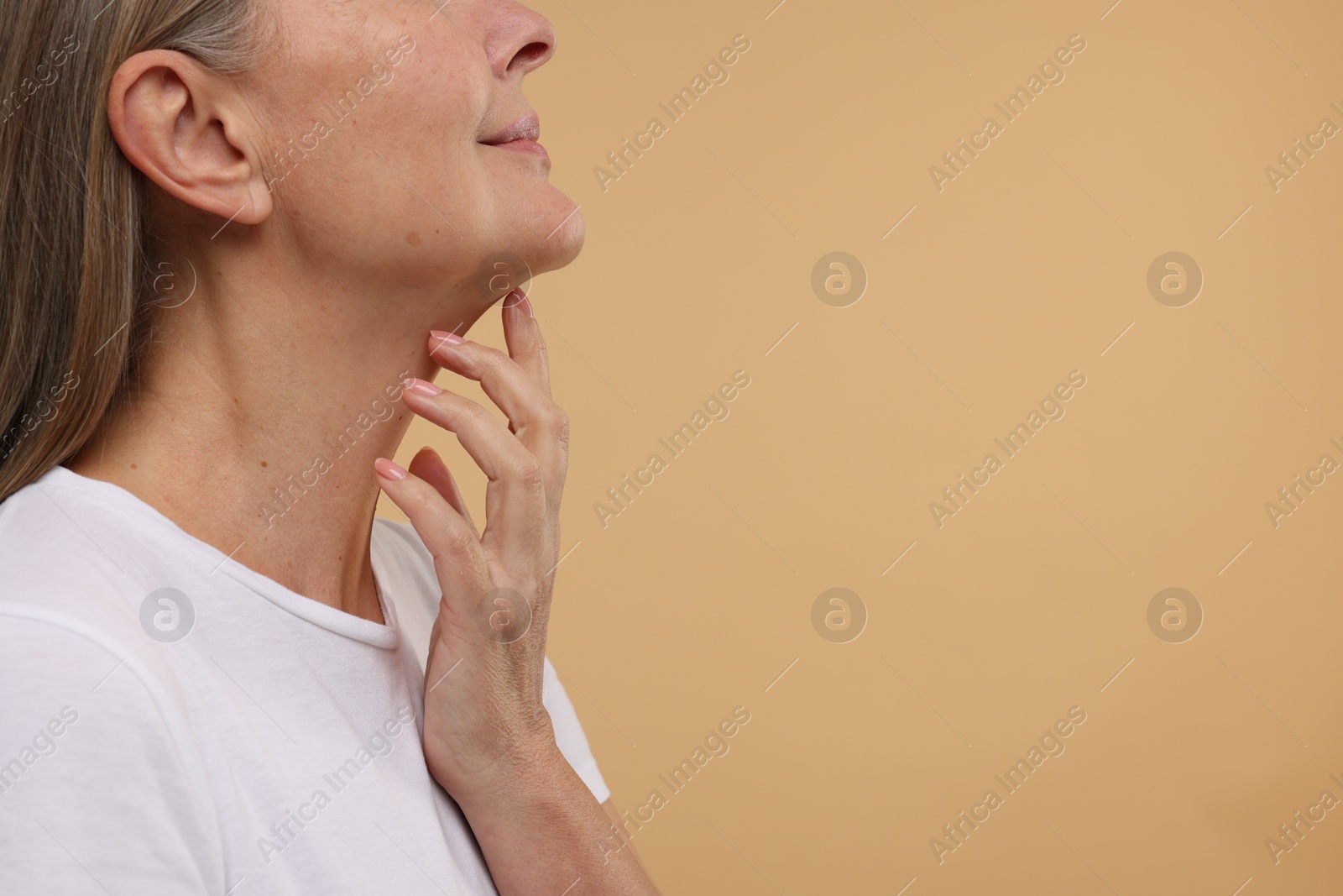 Photo of Mature woman with healthy skin on beige background, closeup. Space for text