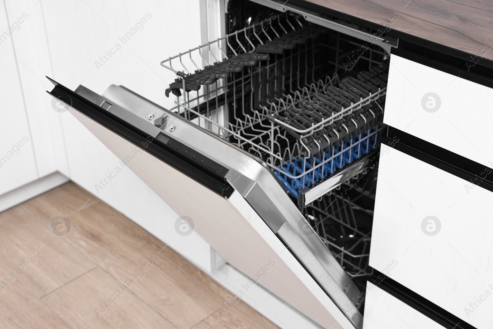 Photo of Built-in dishwasher with open door indoors. Home appliance