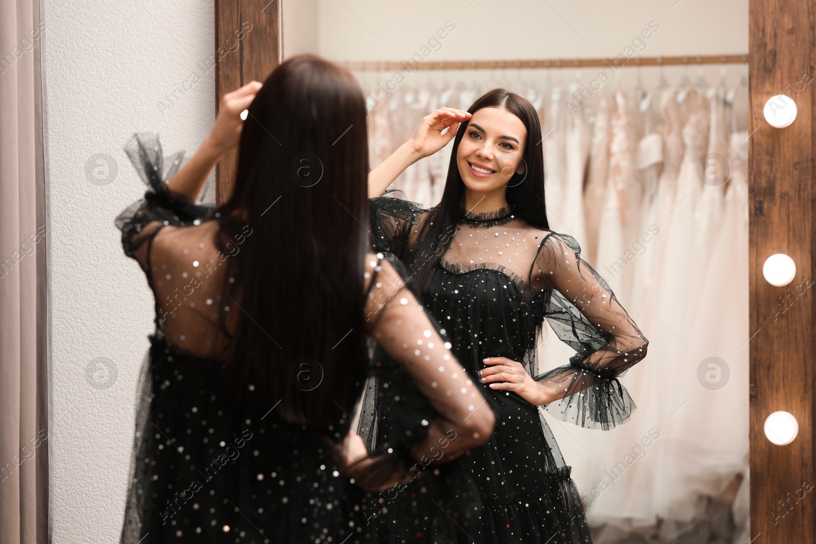 Photo of Woman trying on dress in clothing rental salon