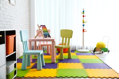 Photo of Stylish playroom interior with toys and modern furniture. Space for design