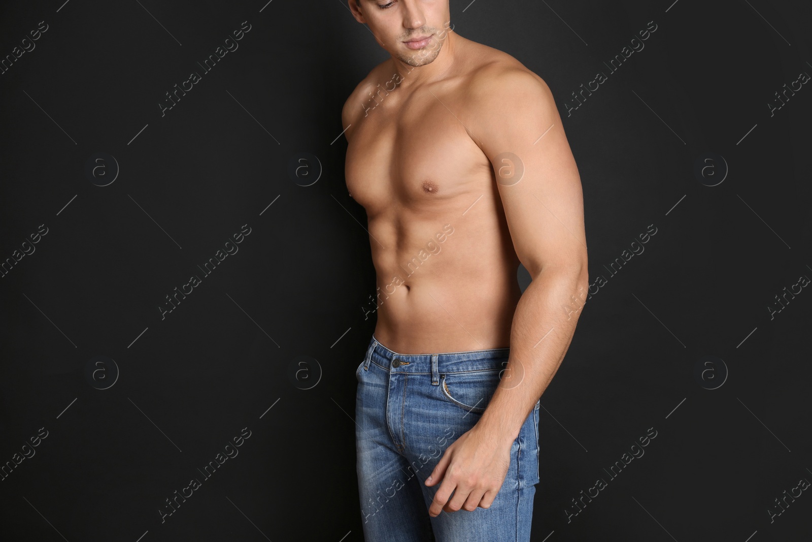 Photo of Man with sexy body on black background, closeup