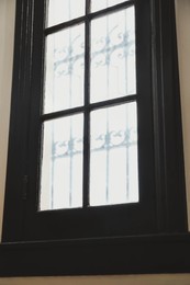 Photo of Window with grid on white wall indoors
