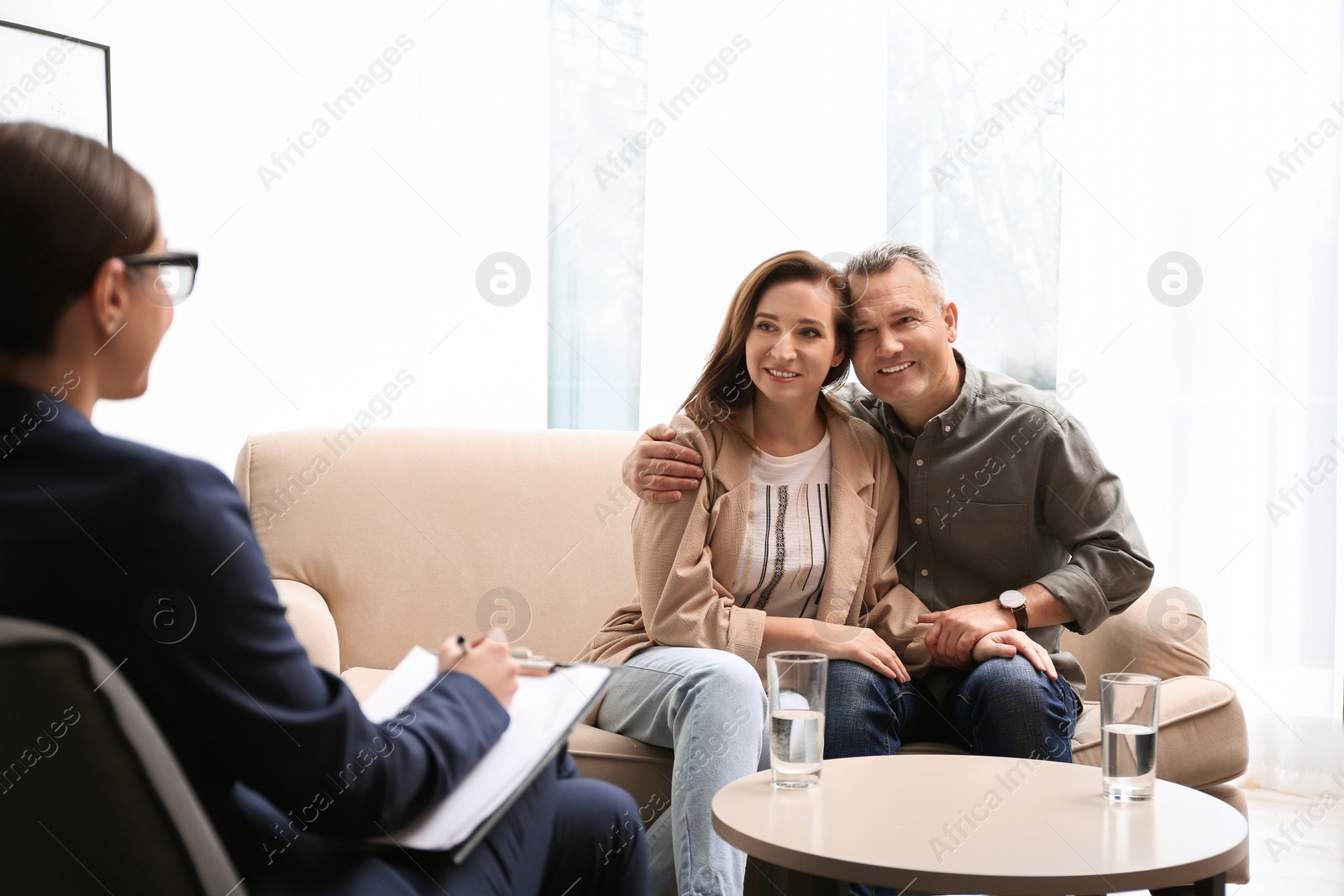 Photo of Psychotherapist and happy couple having meeting in office. Family counselling