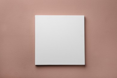 Photo of Blank canvas on pale pink wall. Space for design