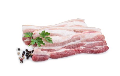 Photo of Pieces of raw pork belly, peppercorns and parsley isolated on white