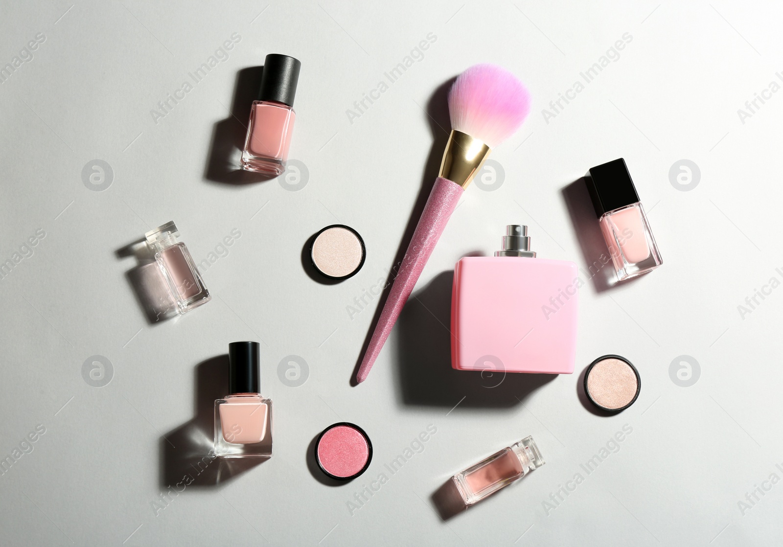 Photo of Flat lay composition with bottles of perfume and cosmetics on grey background