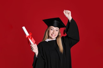 Photo of Happy student with diploma on red background