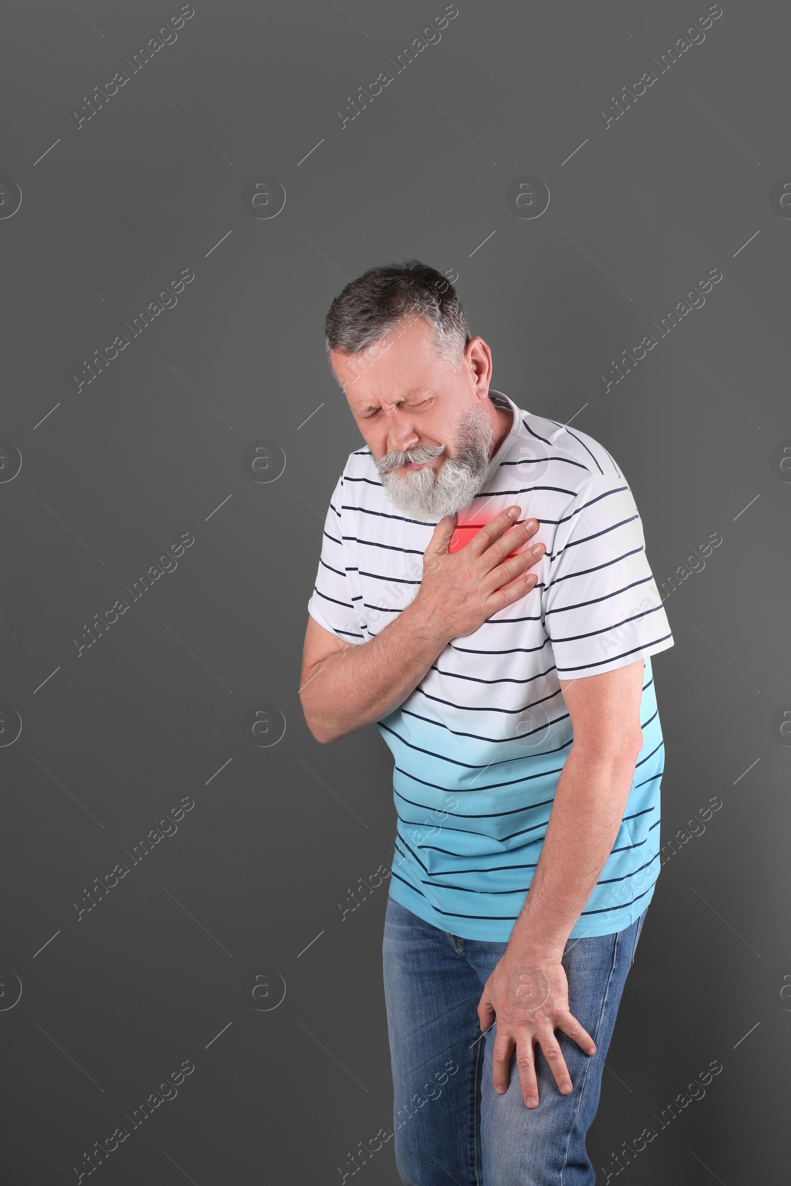 Photo of Mature man having heart attack on gray background