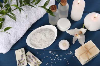 Photo of Beautiful composition with different spa products and candles on blue wooden table. Retreat concept
