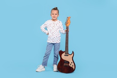 Happy girl with electric guitar on turquoise background