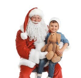 Photo of Little boy with toy bunny sitting on authentic Santa Claus' lap against white background