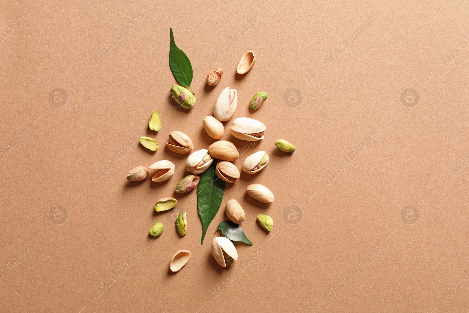 Photo of Composition with organic pistachio nuts on color background, flat lay. Space for text