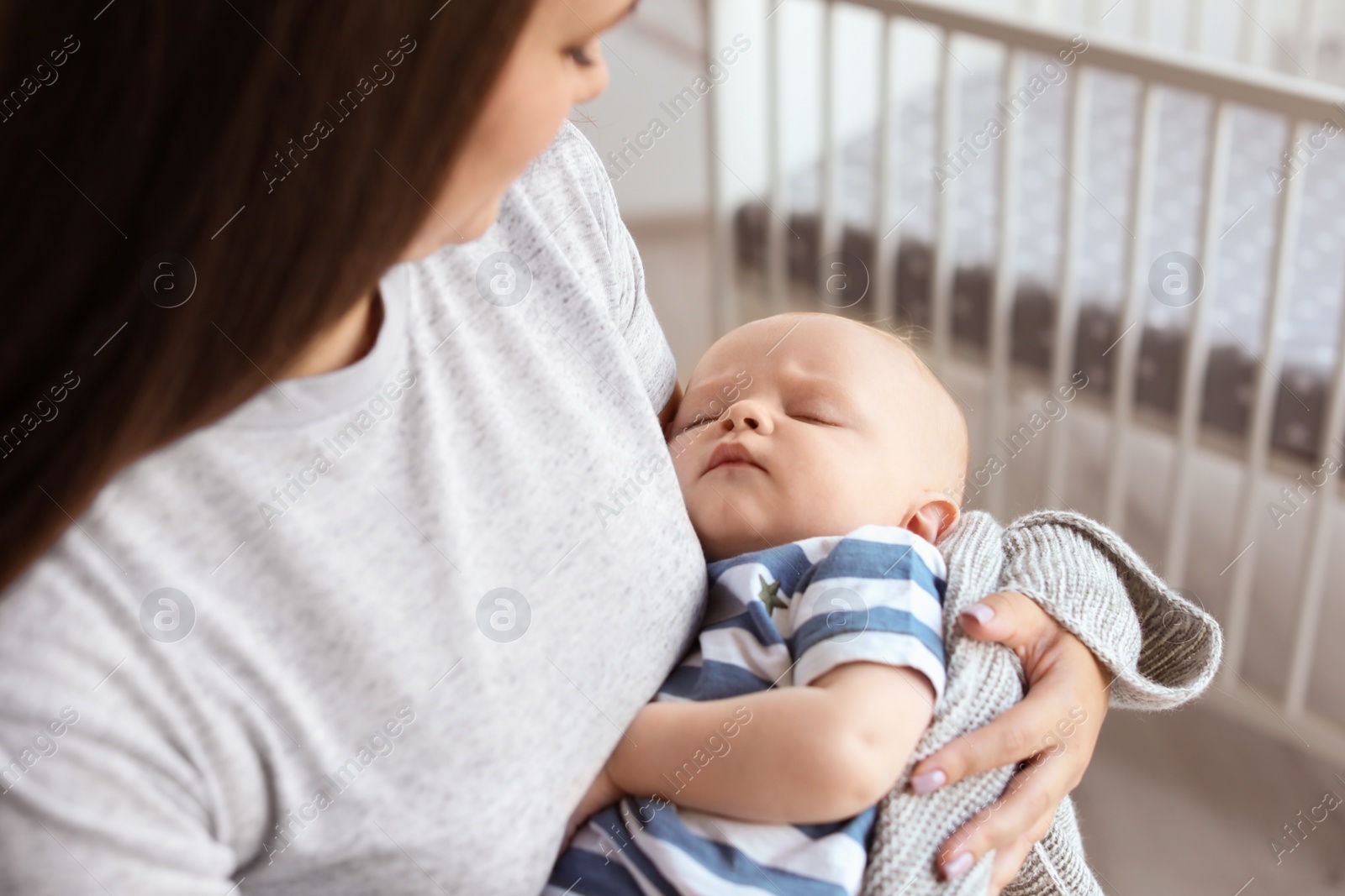 Photo of Mother with her sleeping baby at home, closeup view