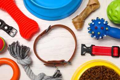 Photo of Flat lay composition with dog collar, toys and food on white wooden table