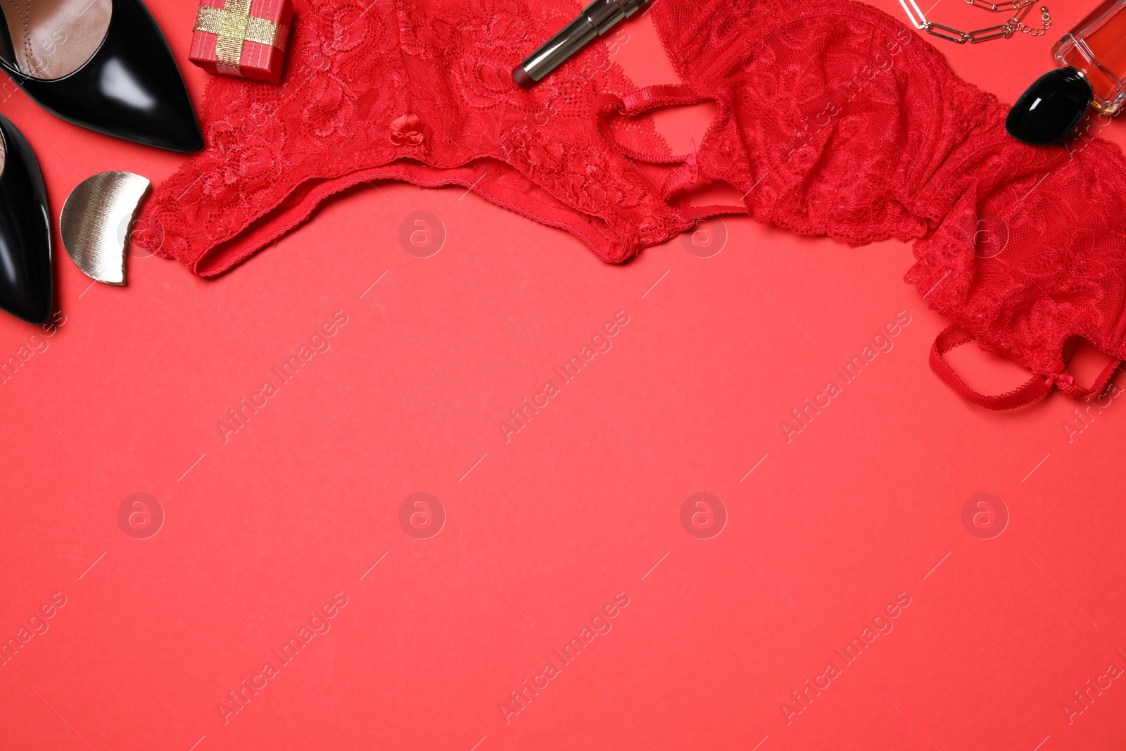 Photo of Stylish set with sexy women lingerie on red background, flat lay. Space for text