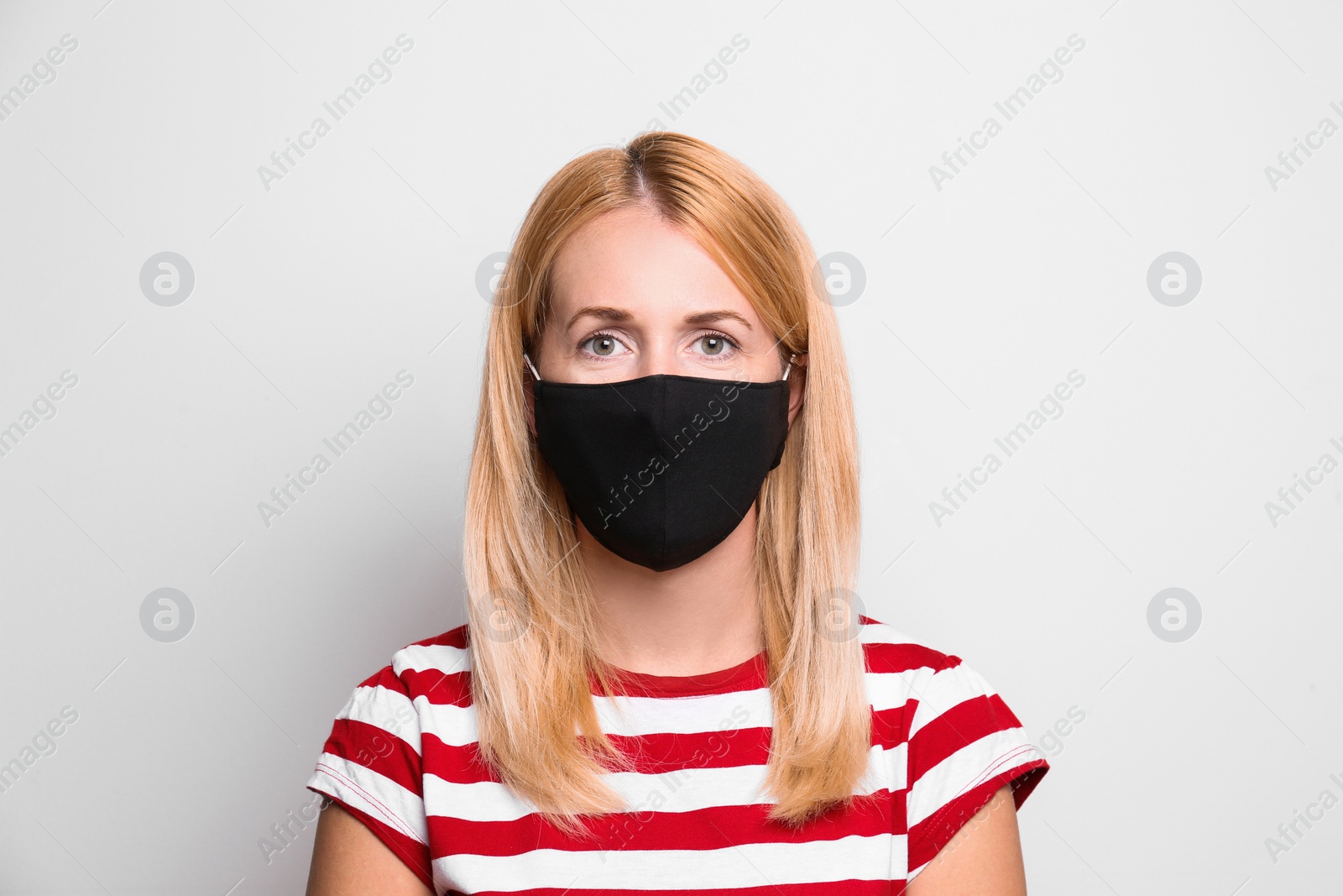 Photo of Woman wearing handmade cloth mask on white background. Personal protective equipment during COVID-19 pandemic