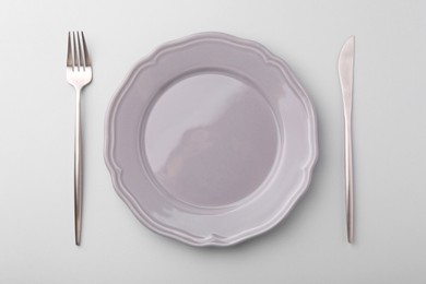 Setting with stylish cutlery on grey table, top view