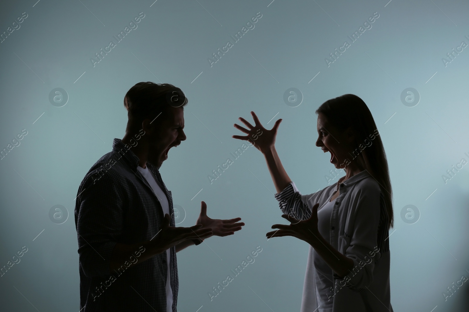 Photo of Silhouette of couple having argument on color background. Relationship problems