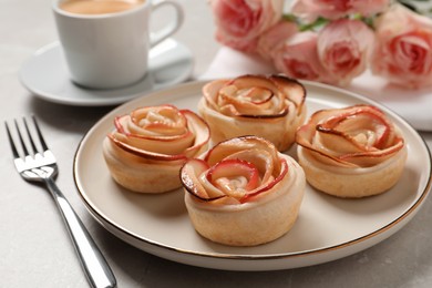 Photo of Freshly baked apple roses served on light table. Beautiful dessert