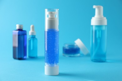 Different cosmetic products on light blue background