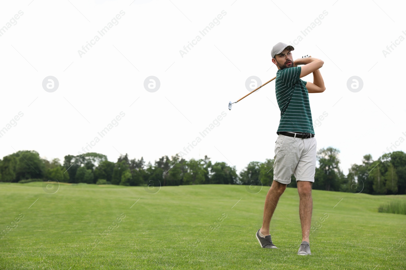 Photo of Man playing golf on green course. Sport and leisure