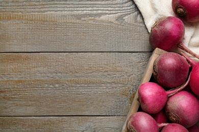 Red turnips on wooden table, flat lay. Space for text